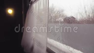 火车从火车站出发。 从火车窗口的视图，车窗上的雨。 人口